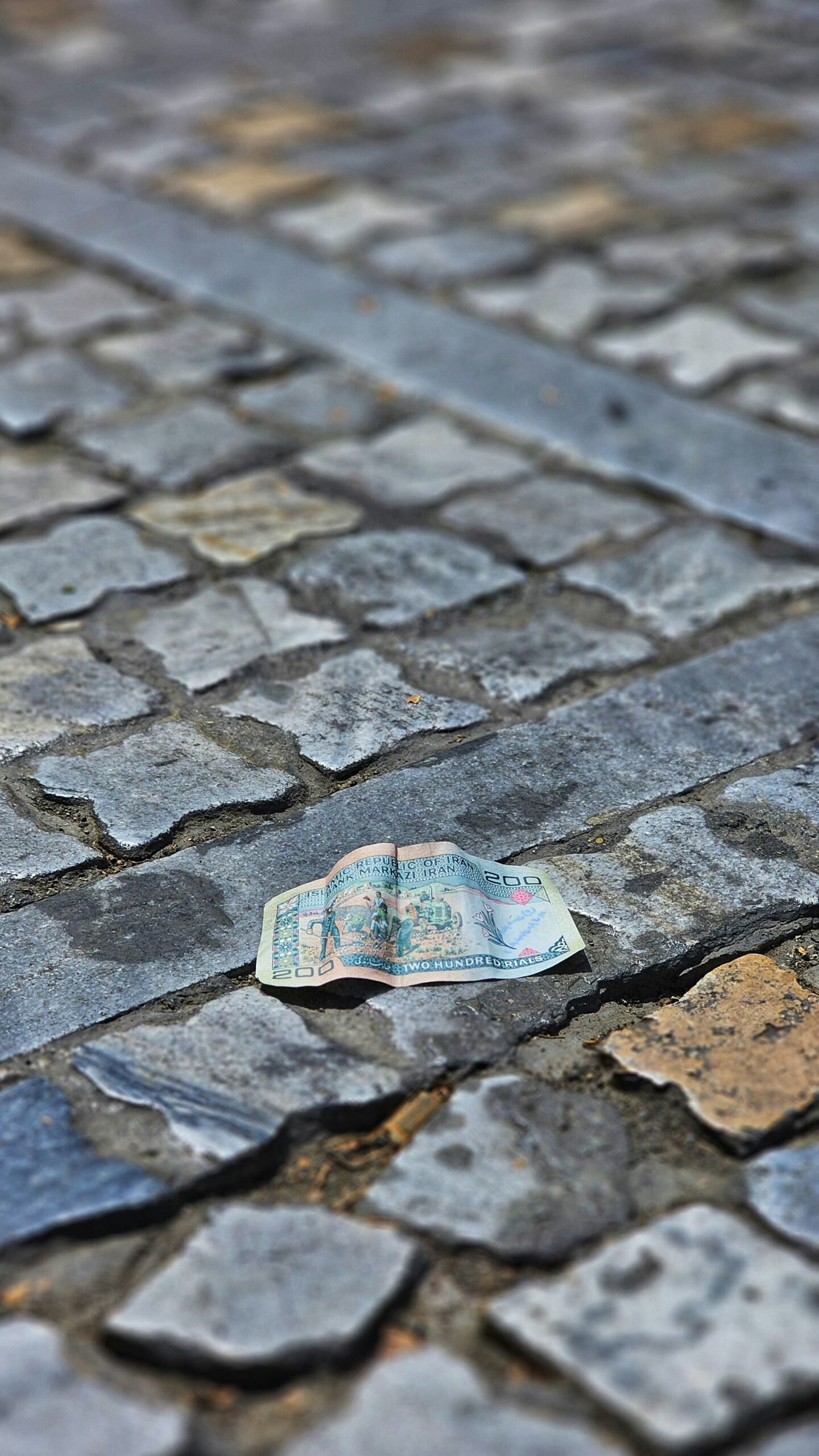 A piece of paper sitting on top of a cobblestone road